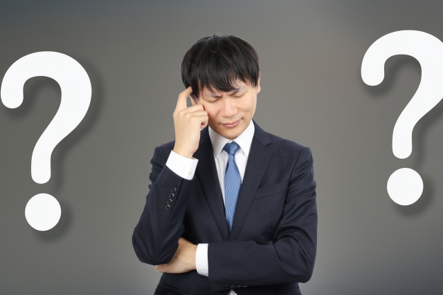 営業転職で年収が下がるか悩むスーツ姿の男性のイメージ画像