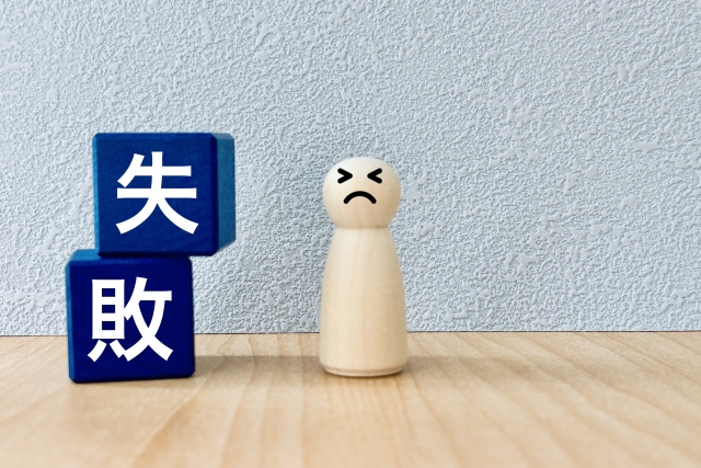失敗と書かれたブロックの横で落ち込む人形のイメージ