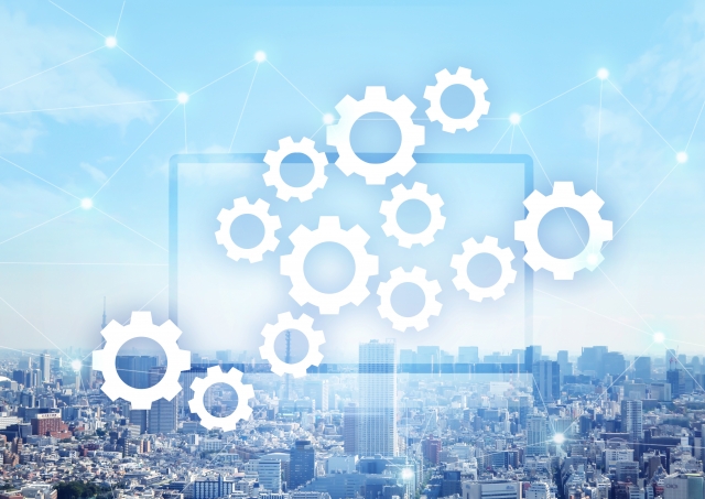 都市の背景に歯車とネットワークが重なったイメージ(反響営業の仕組みを表現)