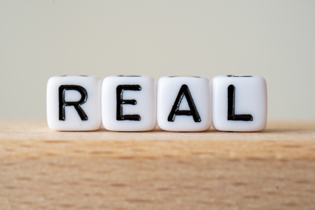 REALの文字が並んだブロックの写真（営業のリアルを象徴するイメージ）