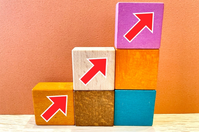 積み上げたブロックと上向き矢印で表す営業の成長イメージ