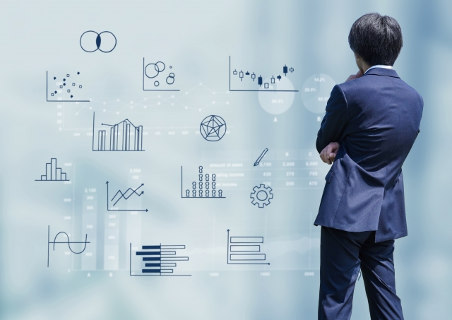 データやグラフを見ながら営業戦略を考えるビジネスパーソンのイメージ