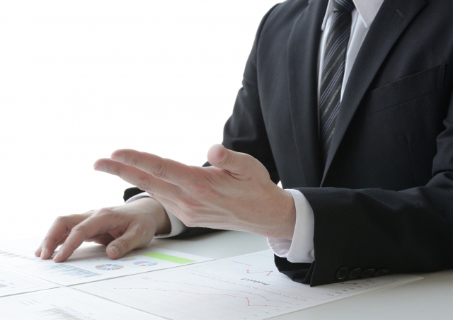 営業担当者が資料を使って顧客に説明しているイメージ