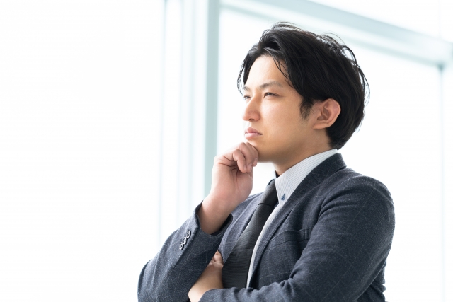 営業転職で失敗を不安に感じながら考え込むスーツ姿の男性
