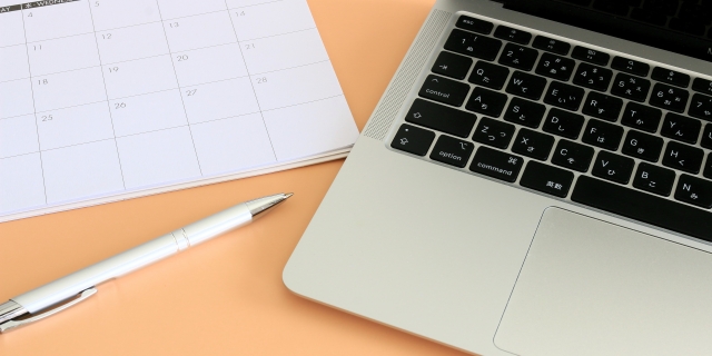 営業の仕事と休日のスケジュールを考えるノートとパソコンのイメージ