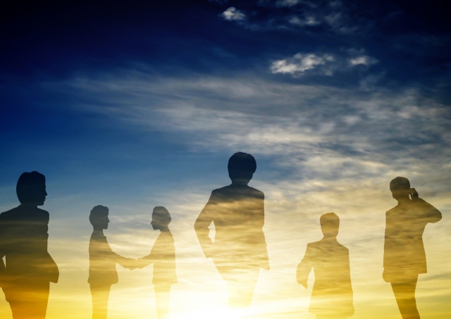 ビジネスパーソンのシルエットとチームの成長を表すイメージ