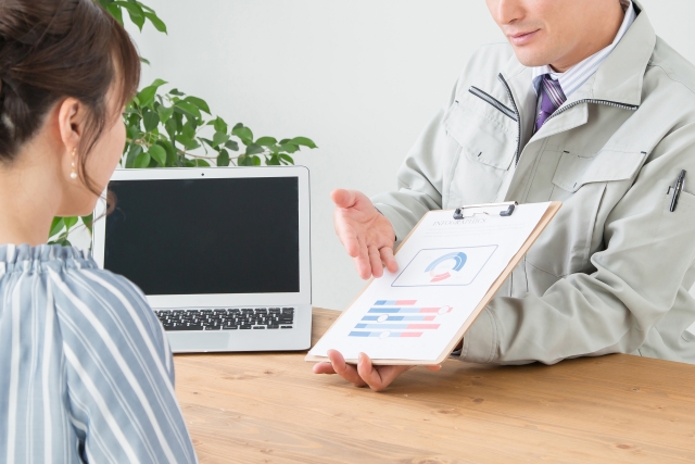 営業担当者が女性に資料を使って説明している様子