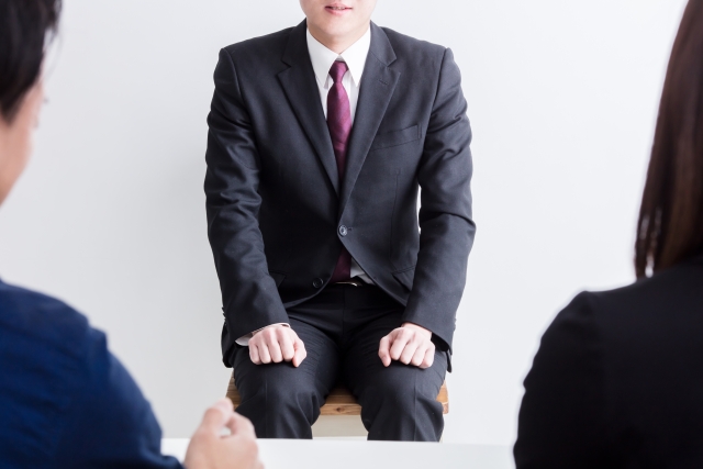 営業職の面接で受け答えをするスーツ姿の男性