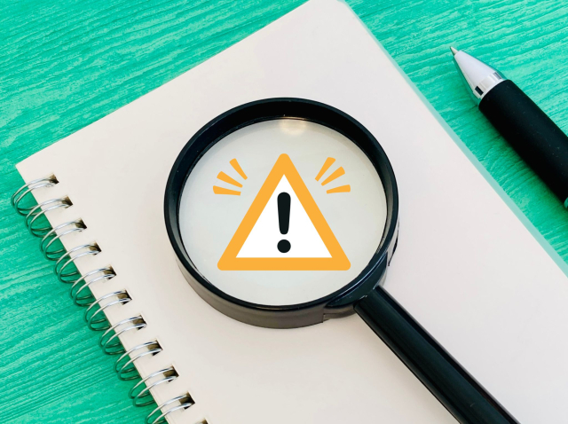 虫眼鏡で注意マークを拡大した、就職カレッジの注意点や登録前の確認ポイントをイメージした画像