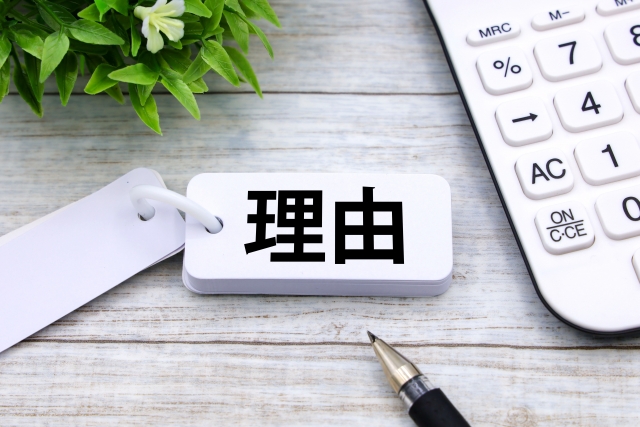 理由と書かれた札と電卓が置かれた、就職カレッジを選ぶ理由や判断材料をイメージした画像