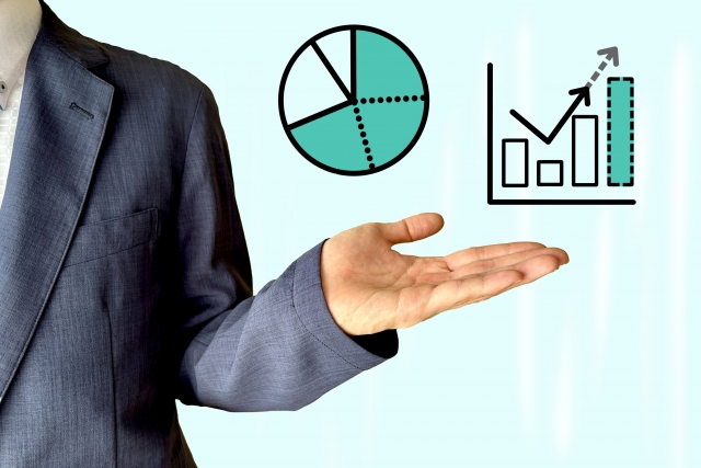 スーツ姿の男性が手を差し出し、売上や成果の向上をイメージしたグラフと円グラフが表示されている