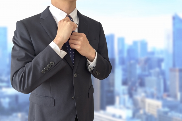スーツ姿の男性がネクタイを整えている営業転職のイメージ画像