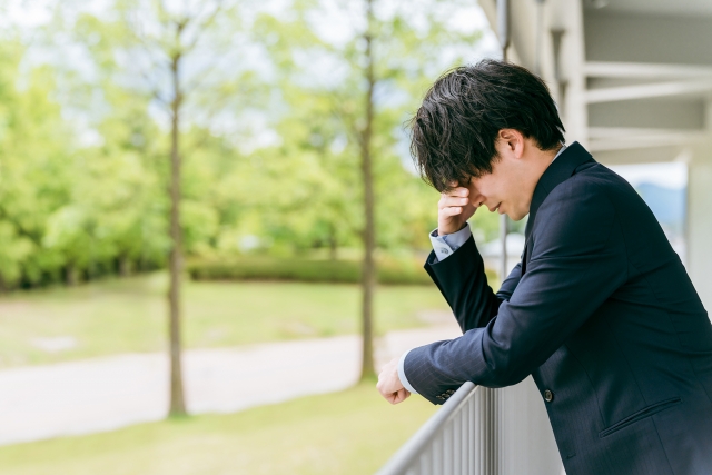 将来への不安を抱えながら転職について考えるスーツ姿の男性