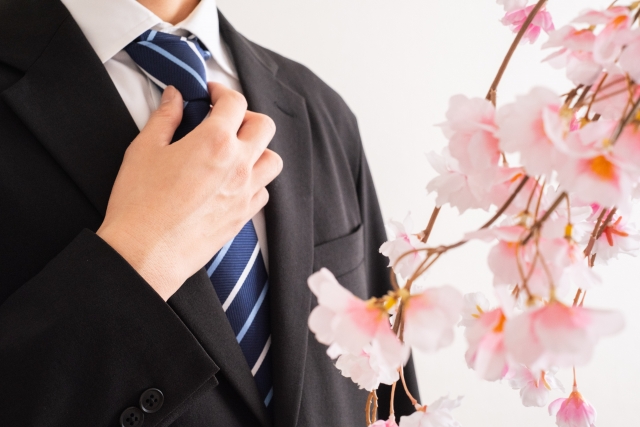 スーツ姿の男性がネクタイを整えている画像。営業未経験から転職活動を始める人のイメージ。