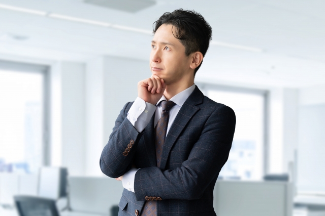 営業職への転職について考えるスーツ姿の男性