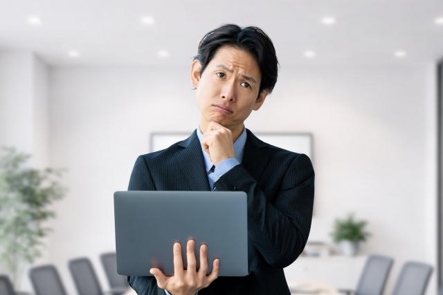 求人票を見ながら悩む営業職志望の男性