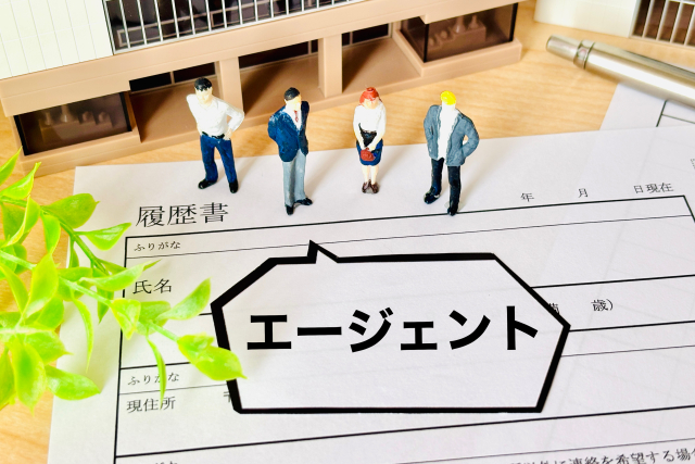 履歴書の上にエージェントと書かれた札が置かれている画像。営業未経験者が転職エージェントを使って求人紹介や選考対策を進める場面を表している。
