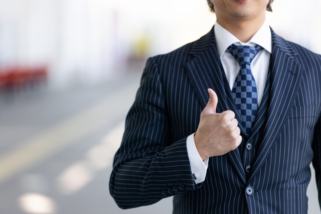 スーツ姿で親指を立てる営業職の男性イメージ画像
