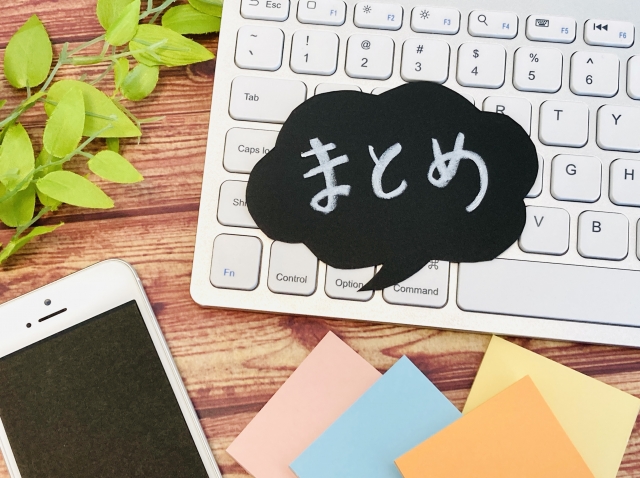 まとめと書かれた吹き出し、キーボード、スマートフォン、付箋が置かれた記事まとめのイメージ画像