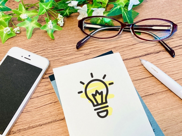 電球のイラストが描かれたメモとスマートフォンのイメージ画像