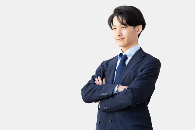 スーツ姿で腕を組む営業職の男性イメージ画像