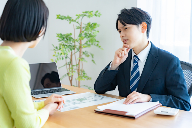 顧客の話を聞きながら説明内容を考える営業マン