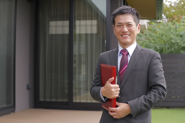 スーツ姿でファイルを持つ営業マン