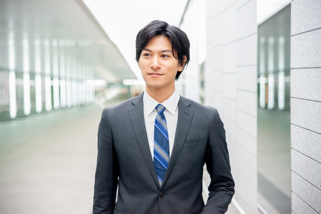 オフィス内を歩くスーツ姿の若い男性