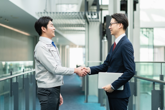 メーカー営業の担当者と取引先が握手する様子